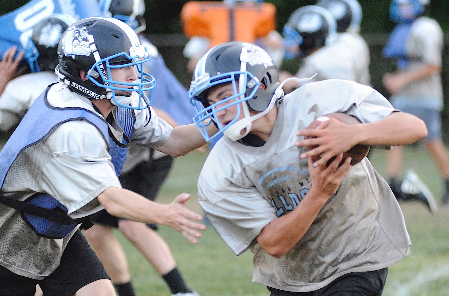 Cutting through the defense. Ball-carrier Jason Rodriguez, a sophomore, is challenged at the line by fellow tenth-grader Adam Ernst in the blue pinnie.